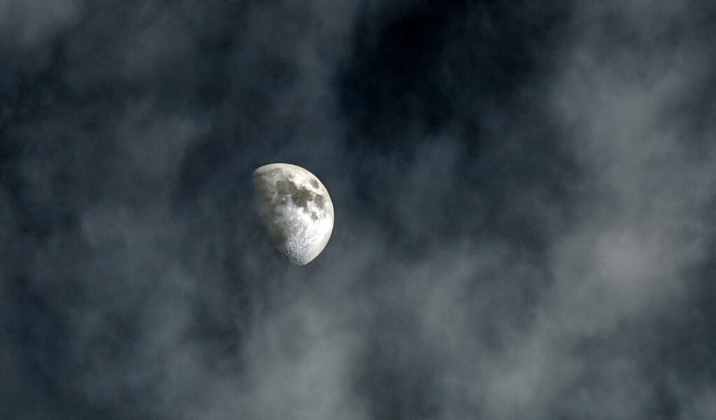 The moon glowing through wispy clouds, evoking peace and wonder in a family nighttime rhythm