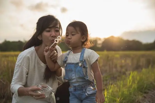🌟 Wisdom Begins in Wonder: A Guide for Parents to Reconnect Through Their Children Mother and young child blowing bubbles together, capturing a moment of play and wonder.