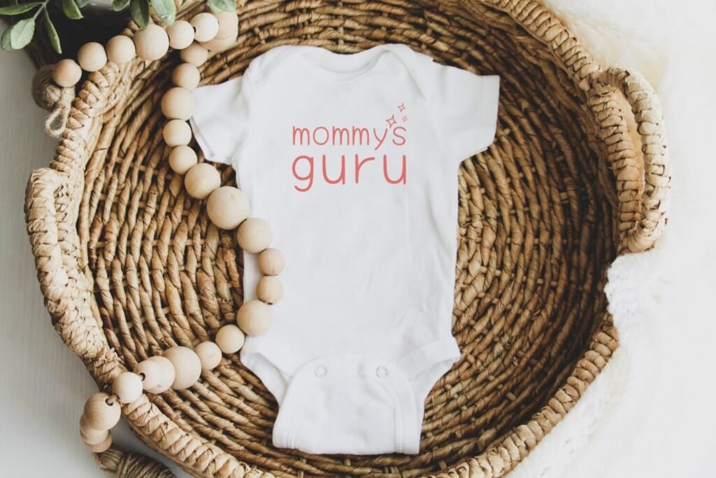 Organic cotton baby onesie with “Mommy’s Guru” slogan, sustainable baby clothing by Little Guru & Co.