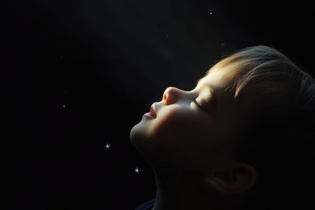 Born With a Blueprint: Your Child Arrived With Inner Wisdom Child’s face turned upward into soft light against a dark background, symbolizing innate wisdom and a child’s soul blueprint.