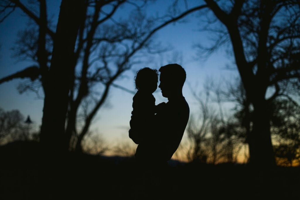 Born With a Blueprint: Your Child Arrived With Inner Wisdom Silhouette of a parent holding a child at dusk, capturing connection, presence, and honoring a child’s natural essence.