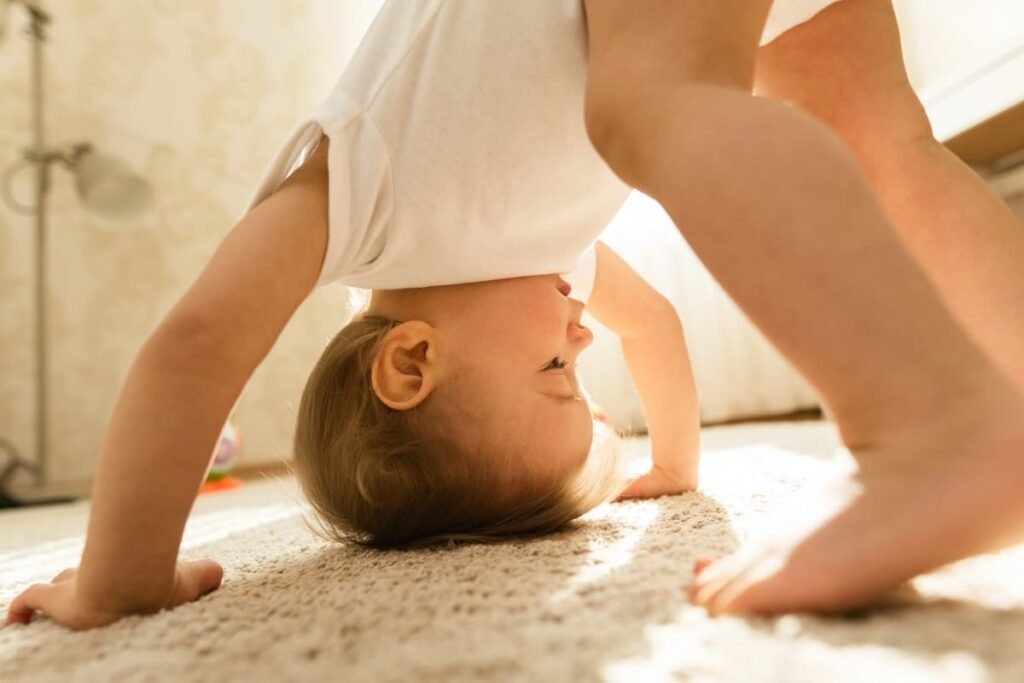 Re-membering: Sacred Wholeness as a Parenting Practice Baby playfully moving upside down on the floor, embodying instinct, strength, and embodied learning.