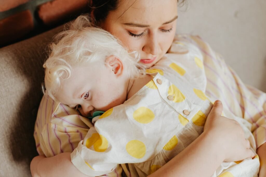 Mother holding her child close in a quiet moment reflecting the tenderness and grief in motherhood