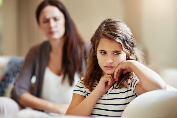 Child appearing upset while a parent speaks, illustrating how language and labels can affect a child’s identity.