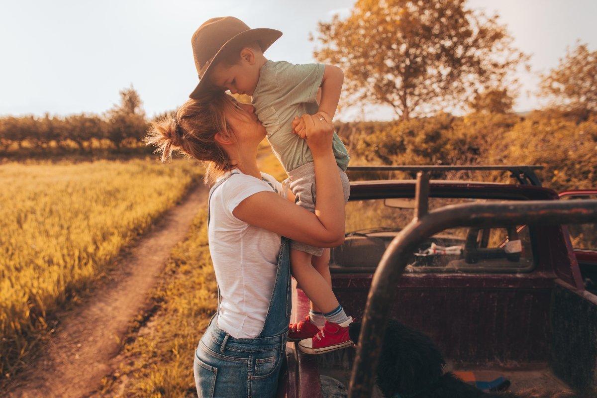 Mother holding child in nature, symbolizing soulful parenting and honoring a child’s sacred design