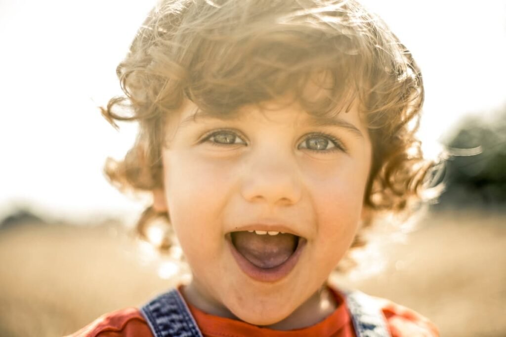 Close-up of joyful child in sunlight representing inner light and conscious children