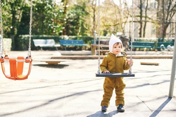 The Gifts Hidden in Our Shadow: Parenting, Healing & the Parts Our Children Reflect Toddler standing independently at a playground representing childhood autonomy and emotional development in parenting and shadow work.