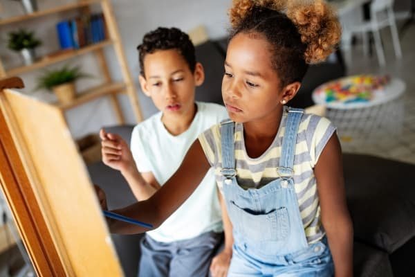 The Gifts Hidden in Our Shadow: Parenting, Healing & the Parts Our Children Reflect Children painting together symbolizing creativity, self-expression, and nurturing individuality through conscious parenting.