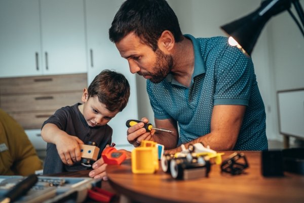 How Our Children Help Us Reparent Ourselves | Conscious Parenting & Healing Father helping son with hands-on activity representing present parenting, emotional bonding, and healthy emotional inheritance.