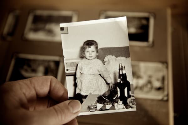 The Gifts Hidden in Our Shadow: Parenting, Healing & the Parts Our Children Reflect Hand holding a childhood photograph symbolizing inner child healing, memory, and parenting through shadow work.