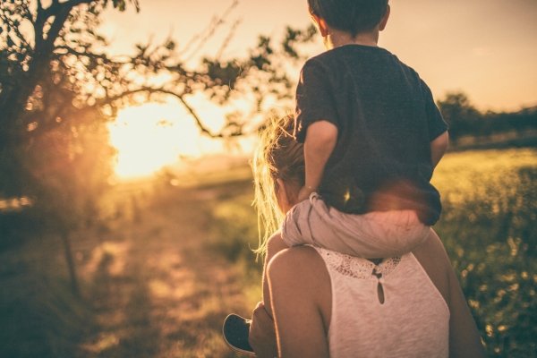 How Our Children Help Us Reparent Ourselves | Conscious Parenting & Healing Mother carrying child at sunset representing conscious parenting, emotional connection, and generational healing.