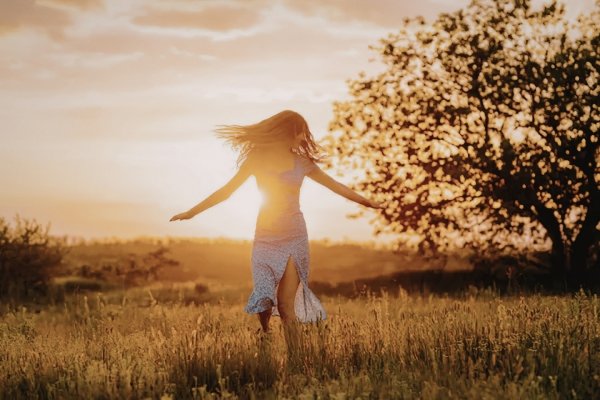 How Our Children Help Us Reparent Ourselves | Conscious Parenting & Healing Woman spinning in a sunlit field symbolizing reparenting, emotional healing, and reconnecting with the inner child.
