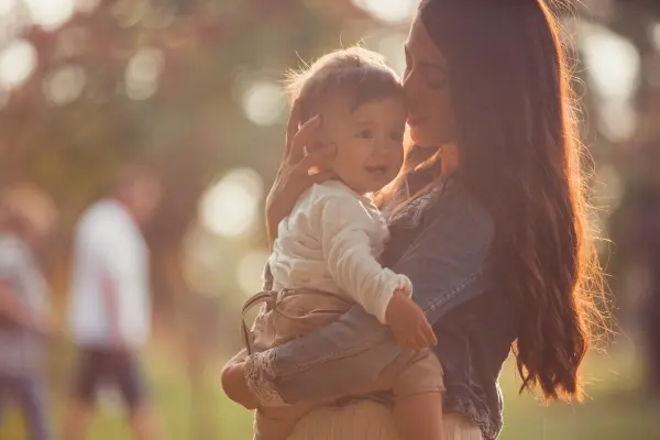 Mother embracing and kissing her baby, representing unconditional love, emotional connection, and healing childhood wounds.