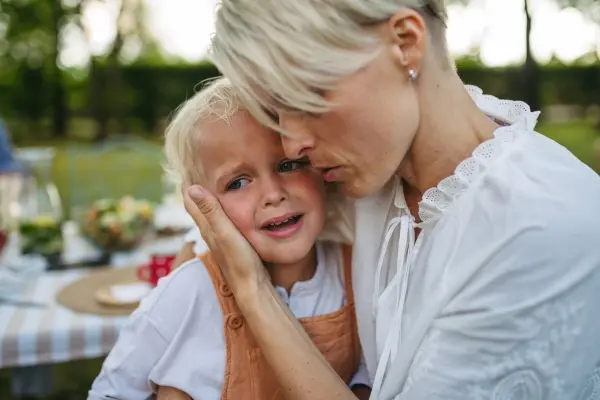 Parent gently comforting a distressed child, demonstrating nervous system regulation and co-regulation.