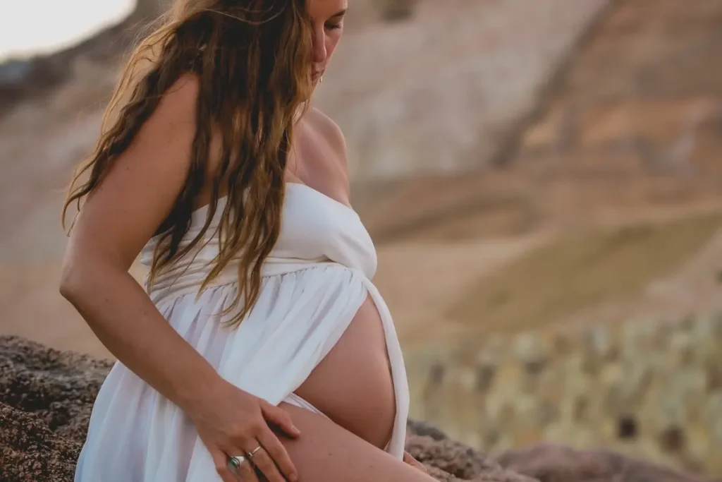 Pregnant woman standing in nature, reflecting birth sovereignty and the journey into conscious parenting