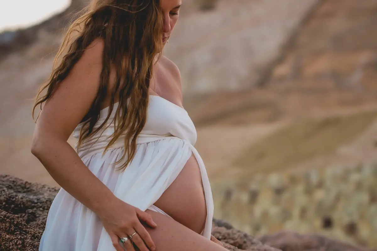 Pregnant woman standing in nature, reflecting birth sovereignty and the journey into conscious parenting