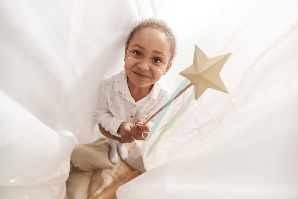 Young child holding a star wand, representing the idea that humans are made of stardust.
