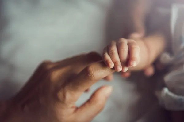 Echoes of the Stars: The Story Behind Our Children's Affirmation Cards Baby reaching for a parent’s hand during a responsive moment of connection